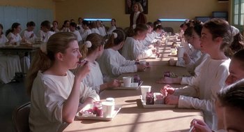 Movie still from “The Handmaid's Tale” (1990), directed by Volker Schlöndorff – A group of people sitting at a long table eating food; Wide shot, High angle