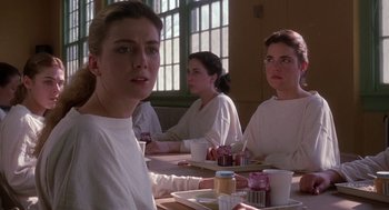 Movie still from “The Handmaid's Tale” (1990), directed by Volker Schlöndorff – A group of people sitting at a table with food; Medium shot, Over the shoulder angle