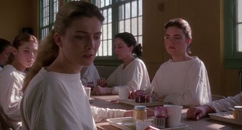 Movie still from “The Handmaid's Tale” (1990), directed by Volker Schlöndorff – A group of people sitting at a table eating; Medium shot, Over the shoulder angle