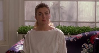 Movie still from “The Handmaid's Tale” (1990), directed by Volker Schlöndorff – A woman in white shirt standing in front of a window; Medium shot, Over the shoulder angle