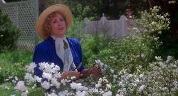 Movie still from “The Handmaid's Tale” (1990), directed by Volker Schlöndorff – A woman holding a pair of shears standing in a garden; Medium shot, High angle