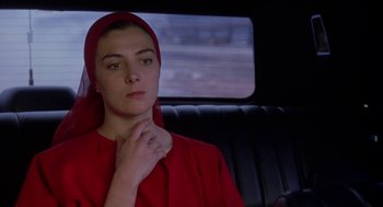 Movie still from “The Handmaid's Tale” (1990), directed by Volker Schlöndorff – A woman sitting in the back of a car wearing a red head scarf; Close Up shot, Low angle