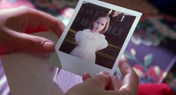 Movie still from “The Handmaid's Tale” (1990), directed by Volker Schlöndorff – A person holding an old photo of a young girl; Extreme Close Up shot, High angle