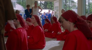 Movie still from “The Handmaid's Tale” (1990), directed by Volker Schlöndorff – A group of women sitting in a room wearing red robes; Wide shot, High angle