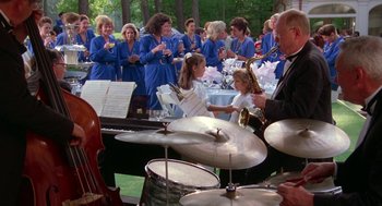 Movie still from “The Handmaid's Tale” (1990), directed by Volker Schlöndorff – A group of people playing musical instruments at a party; Wide shot, High angle