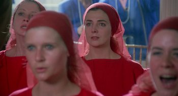 Movie still from “The Handmaid's Tale” (1990), directed by Volker Schlöndorff – A woman in a red dress with a red head covering; Close Up shot, Low angle
