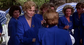 Movie still from “The Handmaid's Tale” (1990), directed by Volker Schlöndorff – A woman in a blue suit talking on a phone; Medium shot, Over the shoulder angle