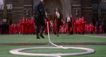 Movie still from “The Handmaid's Tale” (1990), directed by Volker Schlöndorff – A police officer pulling on a rope while a crowd watches; Extreme Wide shot, High angle