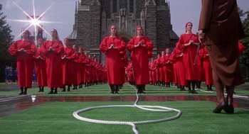 Movie still from “The Handmaid's Tale” (1990), directed by Volker Schlöndorff – A group of people in red robes standing in front of a building; Extreme Wide shot, High angle