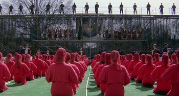 Movie still from “The Handmaid's Tale” (1990), directed by Volker Schlöndorff – A group of people in red robes sitting on a field; Extreme Wide shot, High angle