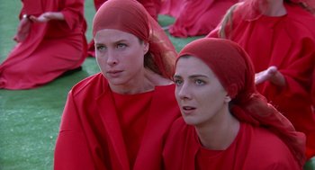 Movie still from “The Handmaid's Tale” (1990), directed by Volker Schlöndorff – A couple of women wearing red clothes sitting next to each other; Close Up shot, High angle