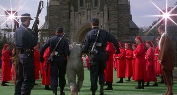 Movie still from “The Handmaid's Tale” (1990), directed by Volker Schlöndorff – A group of men in red robes are standing in front of a building; Wide shot, Low angle