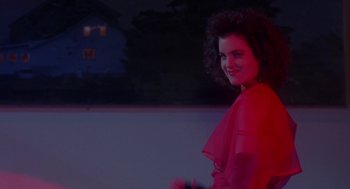 Movie still from “The Handmaid's Tale” (1990), directed by Volker Schlöndorff – A woman in a red dress standing in front of a building; Medium shot, Low angle