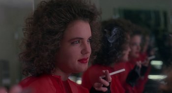 Movie still from “The Handmaid's Tale” (1990), directed by Volker Schlöndorff – A young woman smoking a cigarette in front of a mirror; Close Up shot, Over the shoulder angle