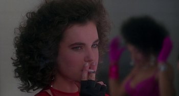 Movie still from “The Handmaid's Tale” (1990), directed by Volker Schlöndorff – A young woman smoking a cigarette while wearing gloves; Close Up shot, Over the shoulder angle