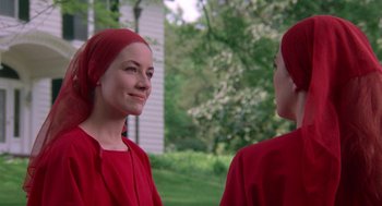 Movie still from “The Handmaid's Tale” (1990), directed by Volker Schlöndorff – A woman in a red dress and a red head scarf; Close Up shot, Over the shoulder angle
