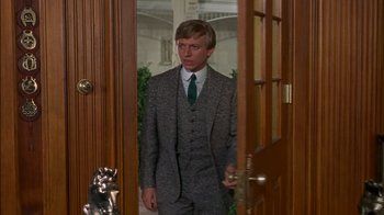 Movie still from “The Happiest Millionaire” (1967), directed by Norman Tokar – A man in a suit and tie standing in front of a door; Medium shot, Low angle