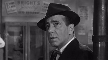 Movie still from “The Harder They Fall” (1956), directed by Mark Robson – An old photo of a man in a suit and a hat; Close Up shot, Low angle