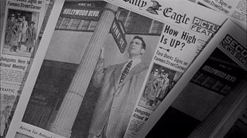 Movie still from “The Harder They Fall” (1956), directed by Mark Robson – An old photo of a man standing on a street corner; Extreme Close Up shot, Low angle