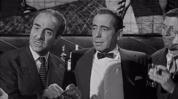 Movie still from “The Harder They Fall” (1956), directed by Mark Robson – A black - and - white photo of two men standing next to each other; Close Up shot, Low angle