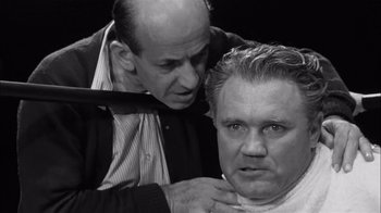 Movie still from “The Harder They Fall” (1956), directed by Mark Robson – A man is shaving another man's neck; Close Up shot, Over the shoulder angle