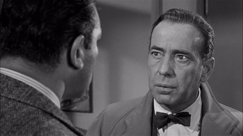 Movie still from “The Harder They Fall” (1956), directed by Mark Robson – A black - and - white photo of a man looking at another man; Close Up shot, Over the shoulder angle