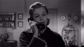 Movie still from “The Harder They Fall” (1956), directed by Mark Robson – A woman talking on a phone in a room; Close Up shot, Low angle