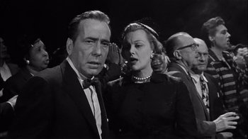 Movie still from “The Harder They Fall” (1956), directed by Mark Robson – A man and a woman standing next to each other; Close Up shot, Low angle