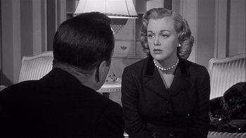 Movie still from “The Harder They Fall” (1956), directed by Mark Robson – An old photo of a man and a woman talking to each other; Medium shot, Over the shoulder angle