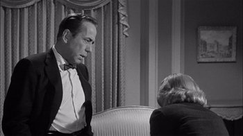 Movie still from “The Harder They Fall” (1956), directed by Mark Robson – A man and a woman are sitting on a couch; Close Up shot, Over the shoulder angle