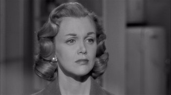 Movie still from “The Harder They Fall” (1956), directed by Mark Robson – An old photo of a woman in a black suit; Close Up shot, Over the shoulder angle