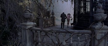 Movie still from “The Haunted Mansion” (2003), directed by Rob Minkoff – A man and a woman walking down a sidewalk; Wide shot, High angle