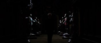 Movie still from “The Haunted Mansion” (2003), directed by Rob Minkoff – A group of people standing in front of each other in a dark room; Wide shot, Over the shoulder angle