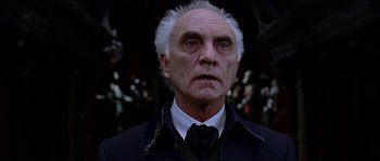 Movie still from “The Haunted Mansion” (2003), directed by Rob Minkoff – An old man with a white beard wearing a suit and tie; Close Up shot, Low angle
