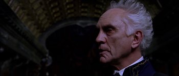 Movie still from “The Haunted Mansion” (2003), directed by Rob Minkoff – An older man wearing a suit and tie looking to his left; Close Up shot, Low angle