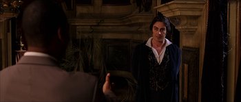 Movie still from “The Haunted Mansion” (2003), directed by Rob Minkoff – A man wearing a black suit and a white shirt; Medium shot, Over the shoulder angle