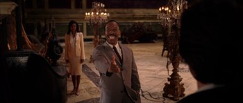 Movie still from “The Haunted Mansion” (2003), directed by Rob Minkoff – A man in a gray suit and a red tie; Medium shot, Over the shoulder angle