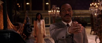 Movie still from “The Haunted Mansion” (2003), directed by Rob Minkoff – A man in a suit and tie pointing at the camera; Medium shot, Low angle