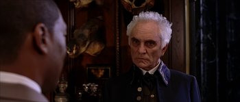 Movie still from “The Haunted Mansion” (2003), directed by Rob Minkoff – An old man in a military uniform stares at the camera; Close Up shot, Over the shoulder angle