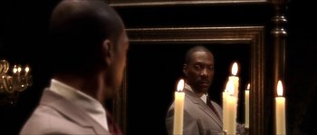 Movie still from “The Haunted Mansion” (2003), directed by Rob Minkoff – A man standing in front of a mirror with candles; Close Up shot, Over the shoulder angle