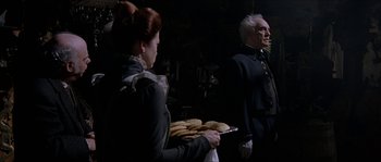 Movie still from “The Haunted Mansion” (2003), directed by Rob Minkoff – A man and a woman holding a tray of food; Medium shot, Over the shoulder angle