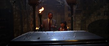 Movie still from “The Haunted Mansion” (2003), directed by Rob Minkoff – A man and a little girl are holding a torch; Medium shot, High angle
