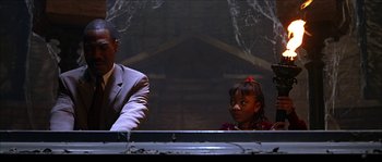 Movie still from “The Haunted Mansion” (2003), directed by Rob Minkoff – A man and a little girl sitting next to each other; Medium shot, Low angle