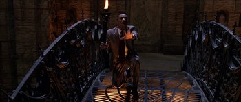 Movie still from “The Haunted Mansion” (2003), directed by Rob Minkoff – A man in a business suit holding a torch; Medium shot, High angle
