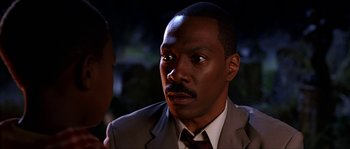 Movie still from “The Haunted Mansion” (2003), directed by Rob Minkoff – A person wearing a suit and tie; Close Up shot, Over the shoulder angle