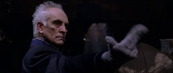 Movie still from “The Haunted Mansion” (2003), directed by Rob Minkoff – An older man holding a gun in a dark room; Close Up shot, Low angle