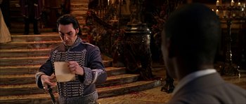 Movie still from “The Haunted Mansion” (2003), directed by Rob Minkoff – A man in a military uniform holding something in his hands; Medium shot, Over the shoulder angle