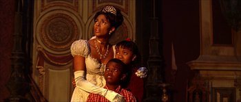 Movie still from “The Haunted Mansion” (2003), directed by Rob Minkoff – A woman and two children dressed as princess tiana and the frog prince; Medium shot, Low angle