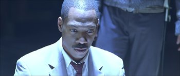 Movie still from “The Haunted Mansion” (2003), directed by Rob Minkoff – A person wearing a suit and tie; Close Up shot, High angle