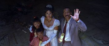 Movie still from “The Haunted Mansion” (2003), directed by Rob Minkoff – A man and a woman and two children in formal wear; Medium shot, Low angle